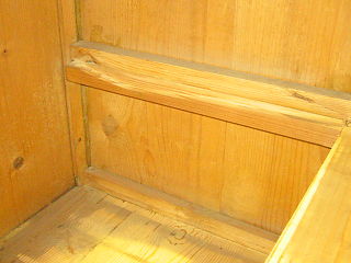 1   Das Innere einer Kommode mit sehr stark ausgearbeiteten Laufleisten. Auf den Laufleisten laufen die Schubladenseiten.