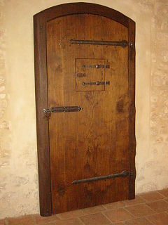 5   Die Tür von außen mit dem Fenster für Brot und Wasser sowie einem Vorhängeschloss.