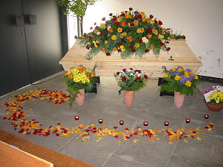 6   Auch ein unbehandelter Kiefernsarg kann durch ausgewählte Blumen und Gestecke ein liebevolles und warmes Bild der Verstorbenen geben.